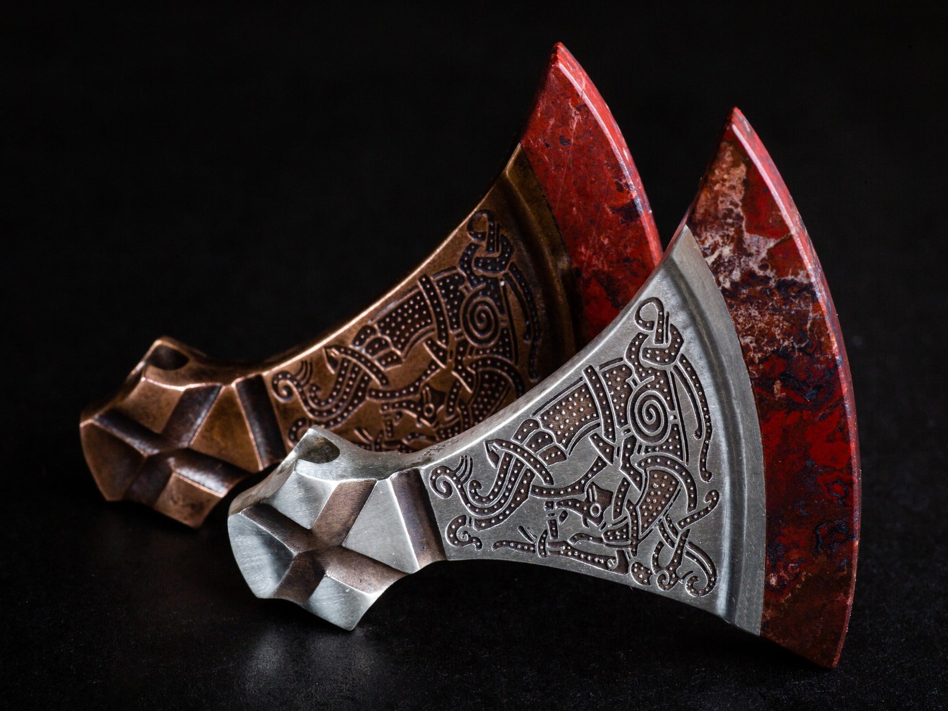 large silver and bronze pendants with red blades
