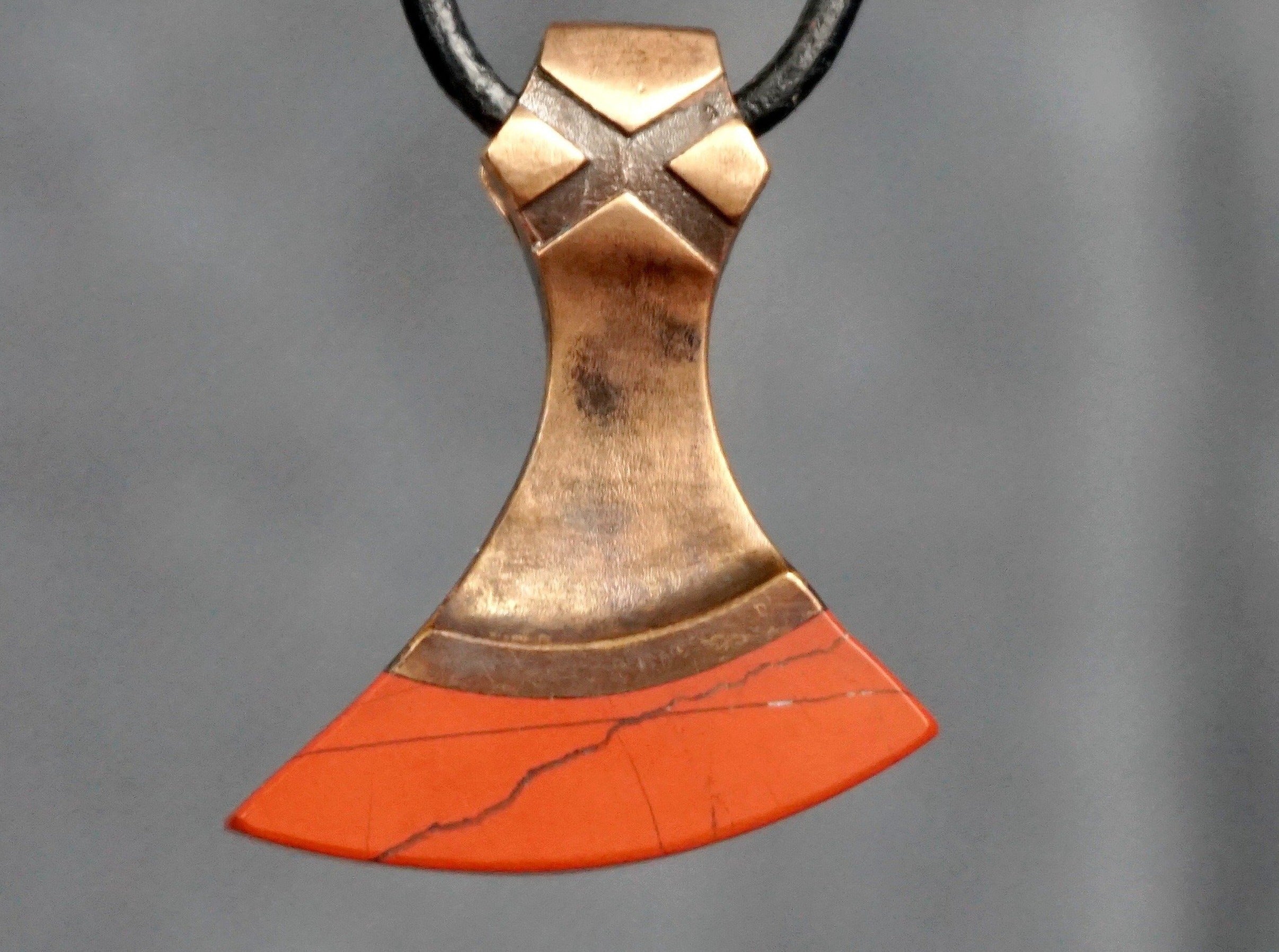 small axe made of bronze and scarlet red srone