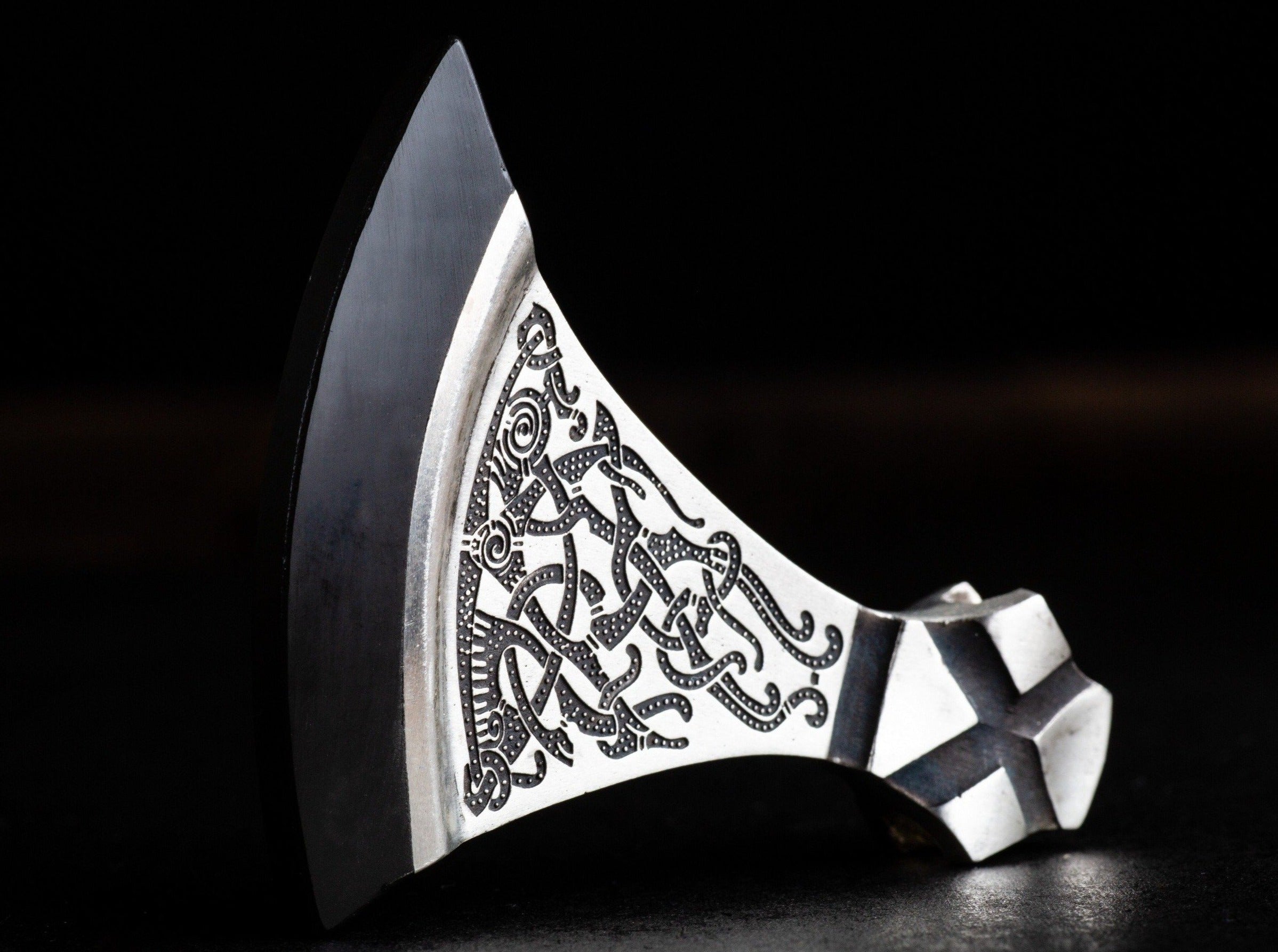 black stone edge and foliate ornament on a silver axe pendant