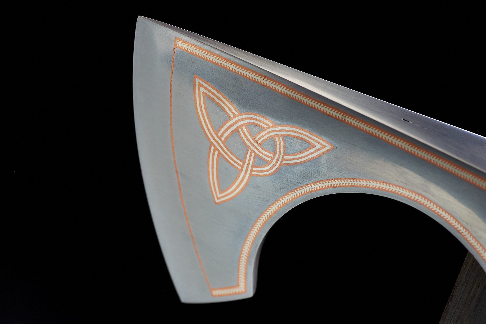 Macro detail of hand-applied copper and silver inlay work