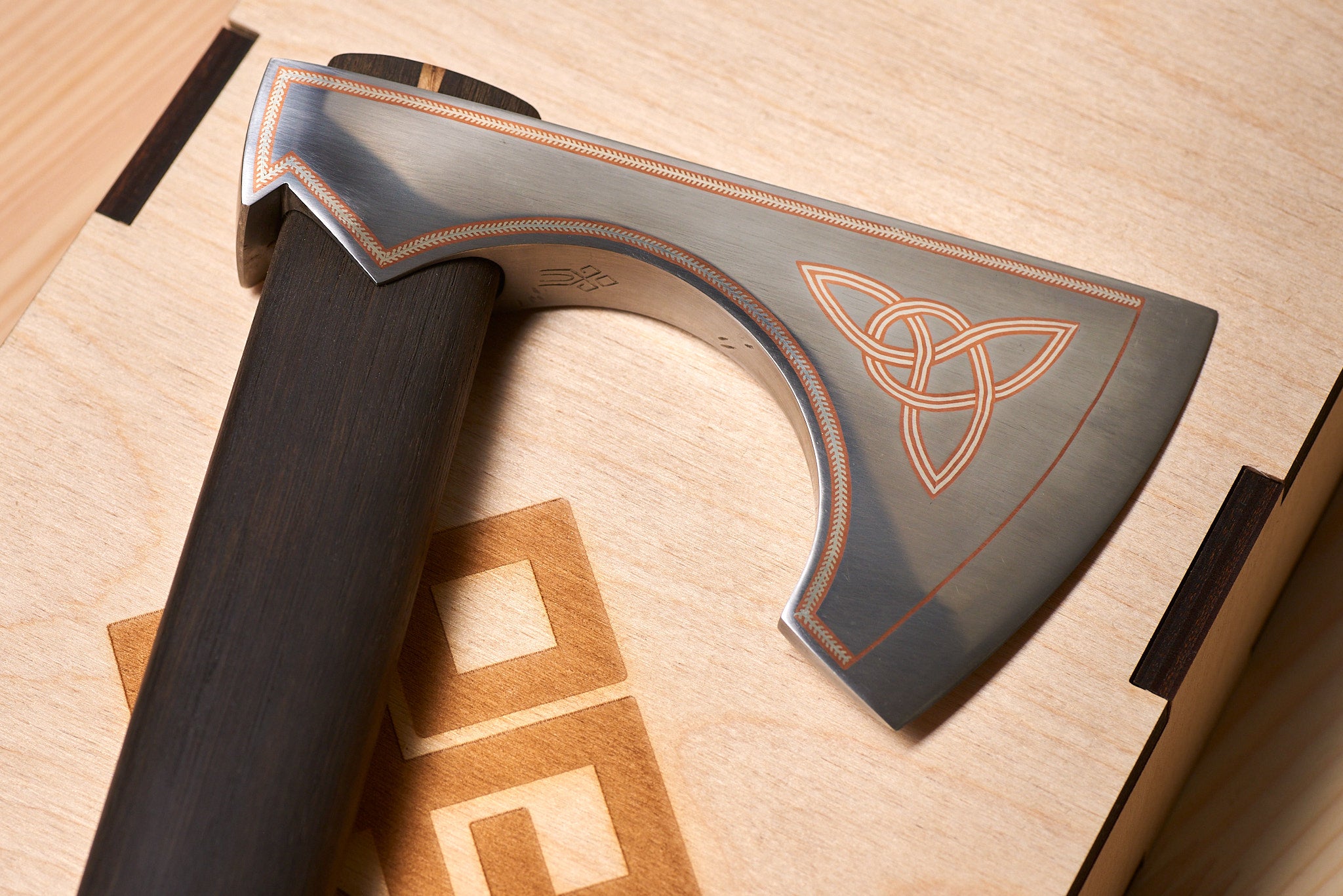 Studio presentation of premium collectible metal art axe