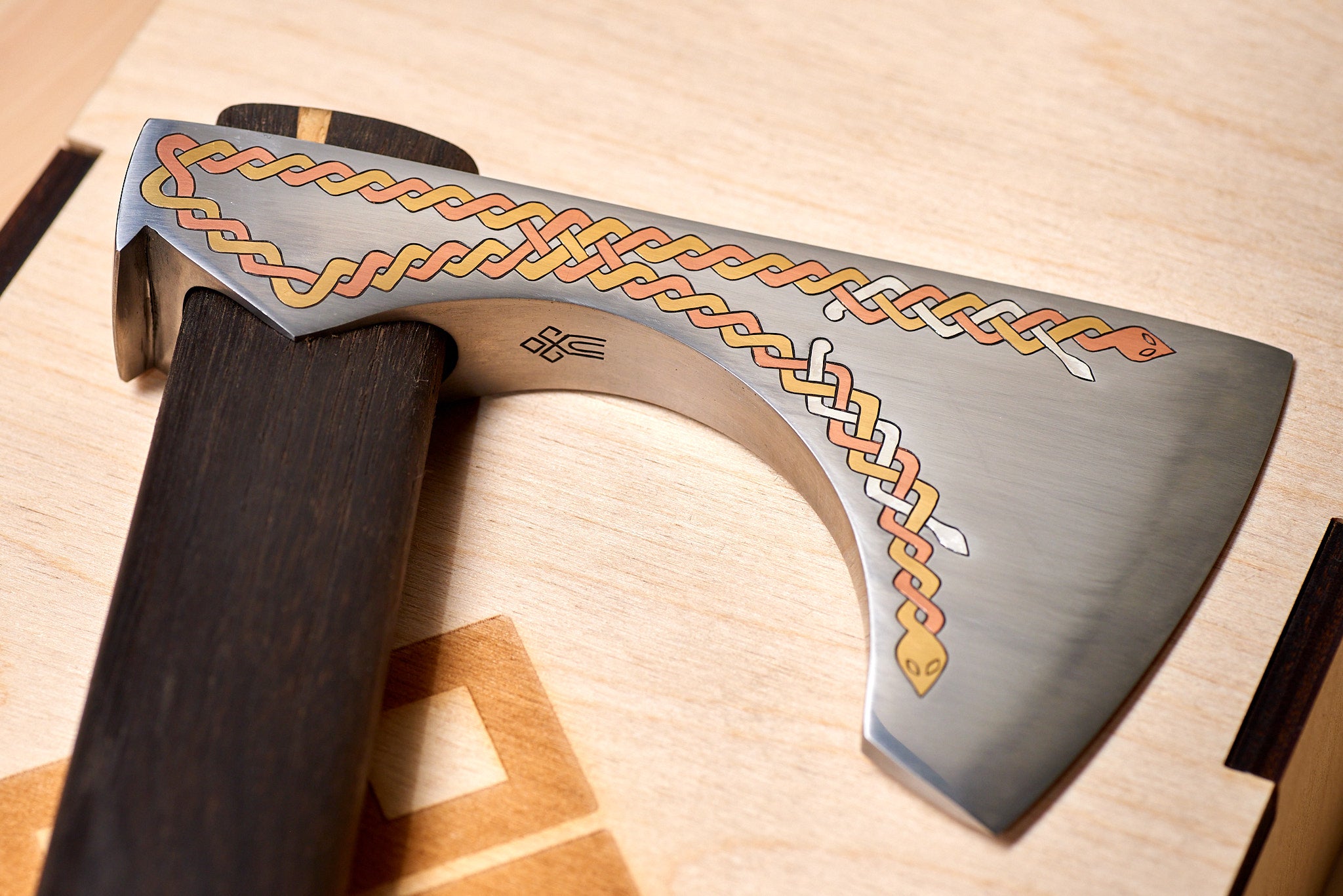 Light reflection highlighting copper, silver, and brass inlays