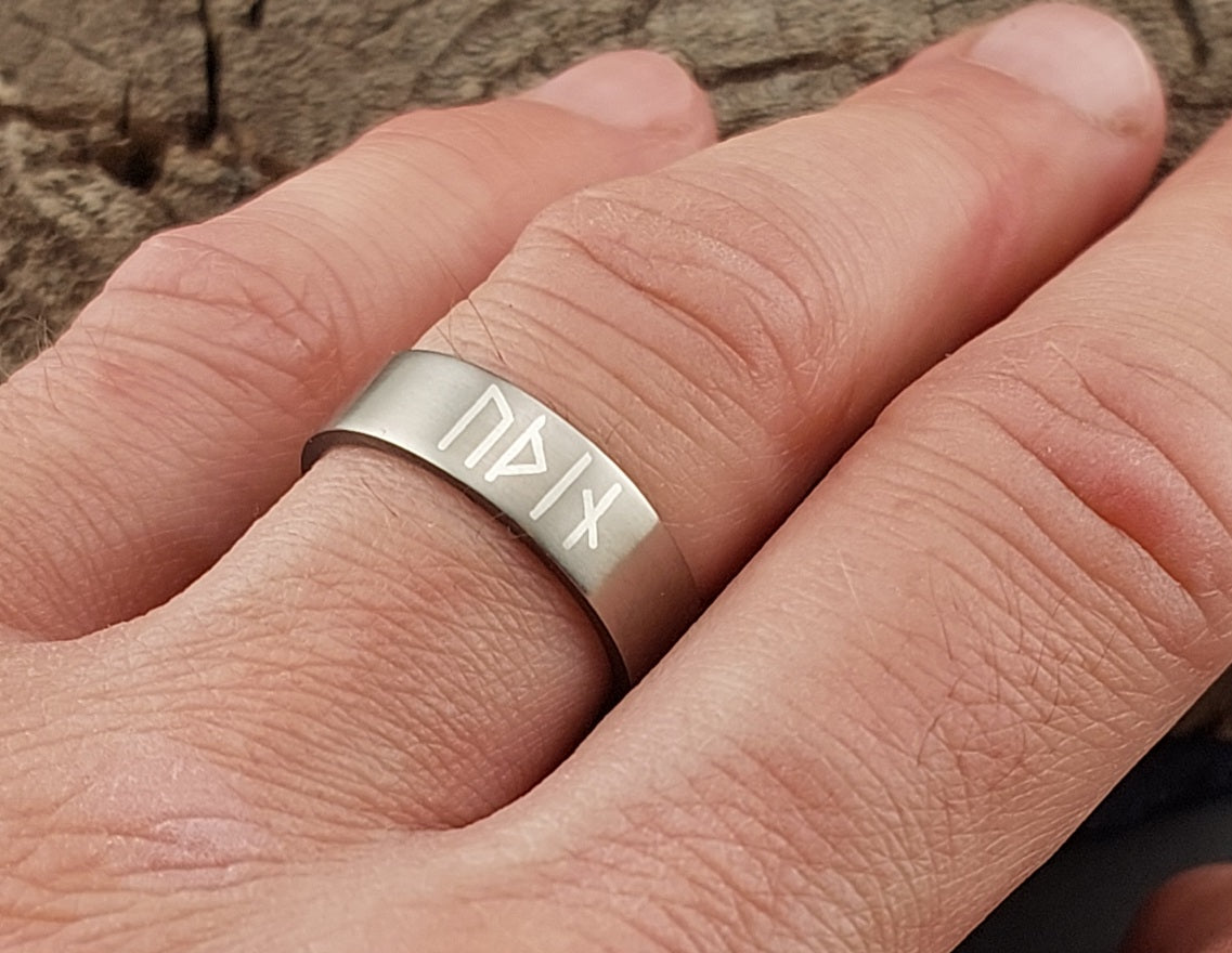 Handmade titanium Odin rune ring worn on finger, featuring Younger Futhark silver inlay and brushed matte Nordic style finish.