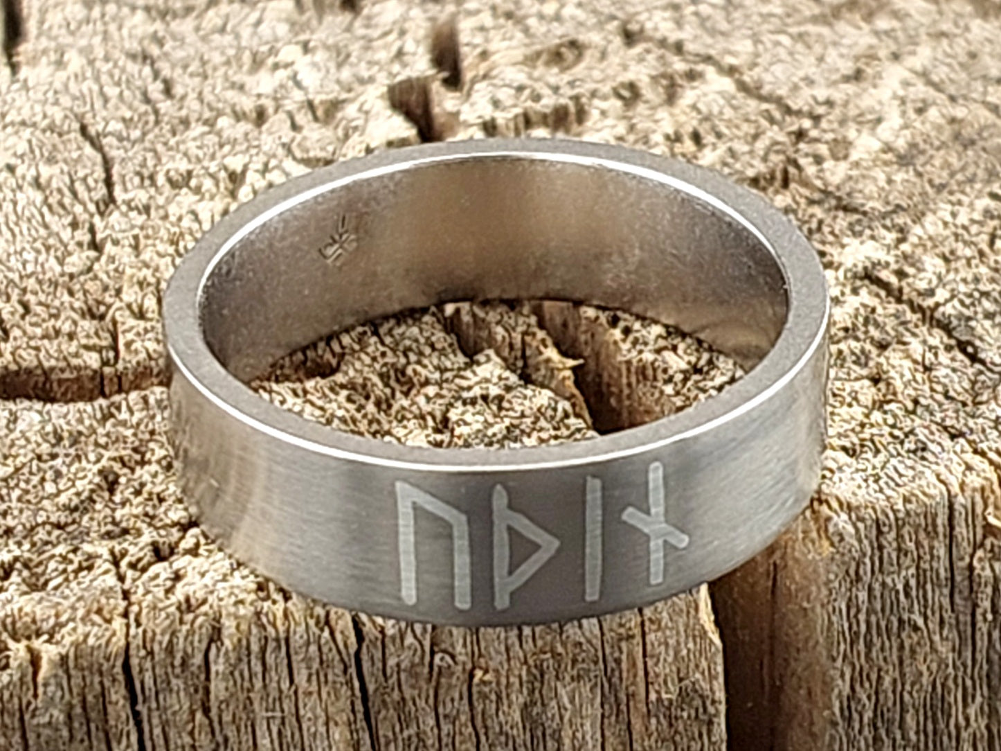Premium handmade titanium band ring with Norse Odin runes in silver inlay, minimalist Scandinavian inspired jewelry design.
