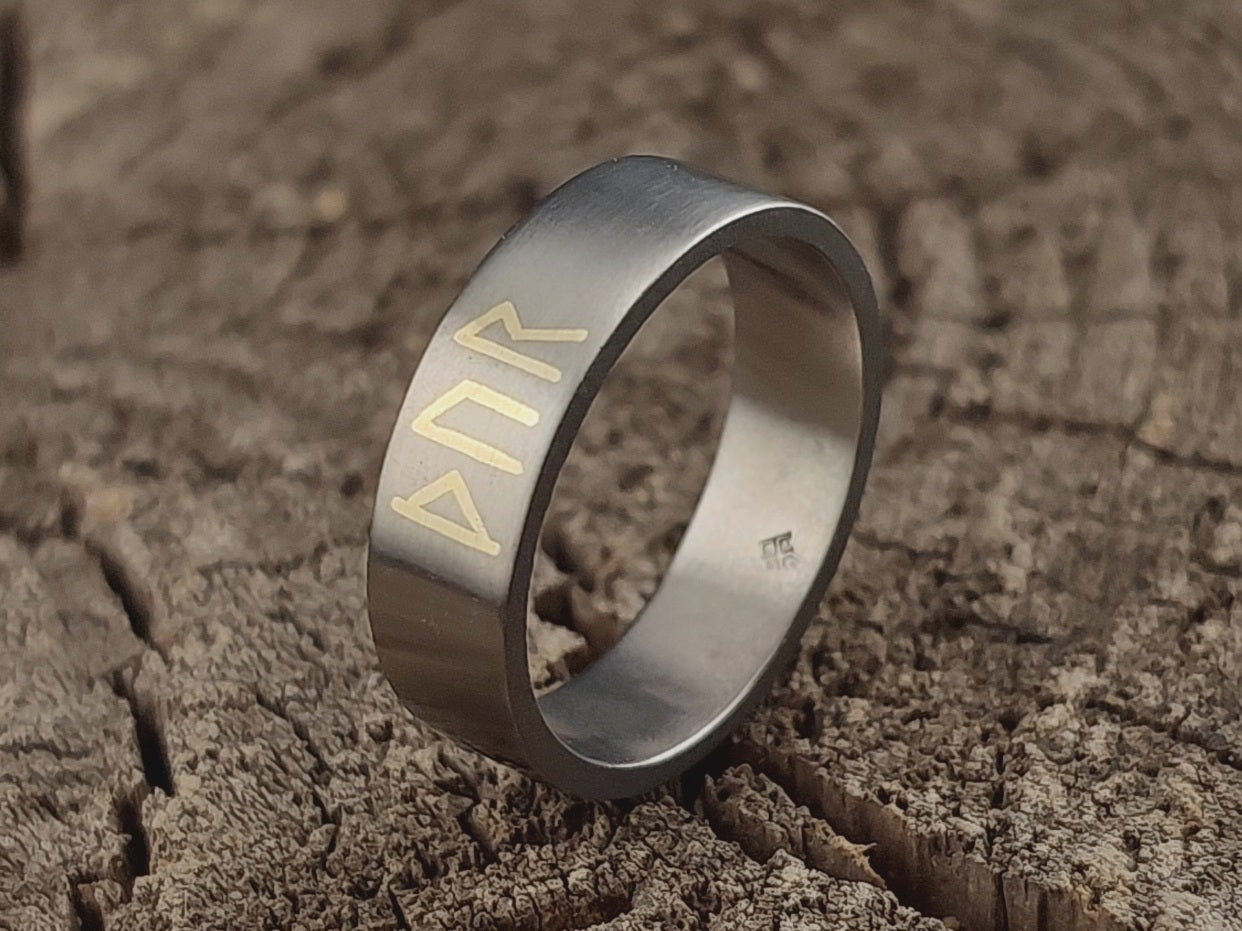 Close-up of the Younger Futhark Thor rune inscription with traditional sterling silver or brass inlay in Grade 2 titanium.
