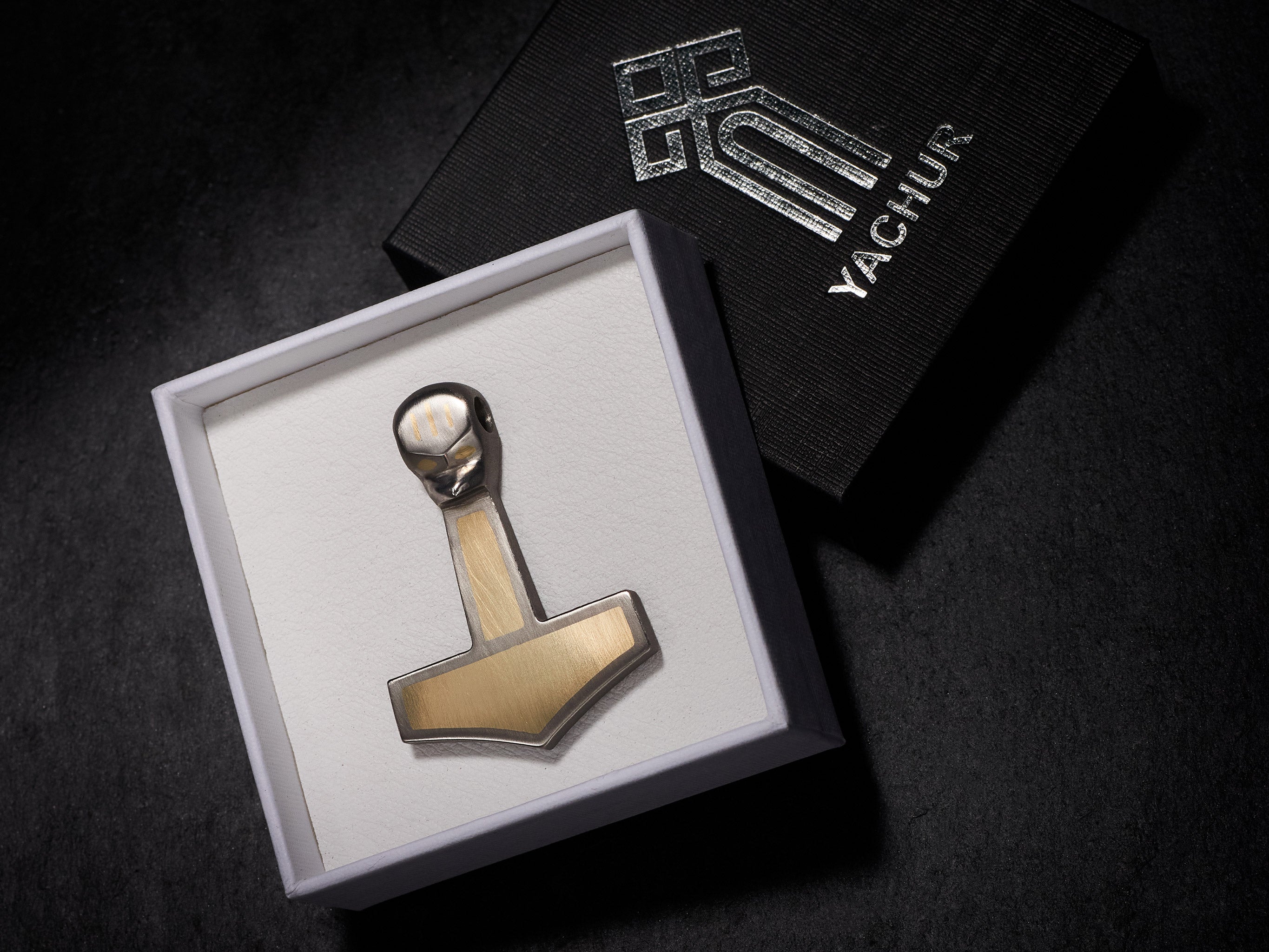 Handmade titanium Thor’s hammer pendant with brass inlay in a Yachur branded box