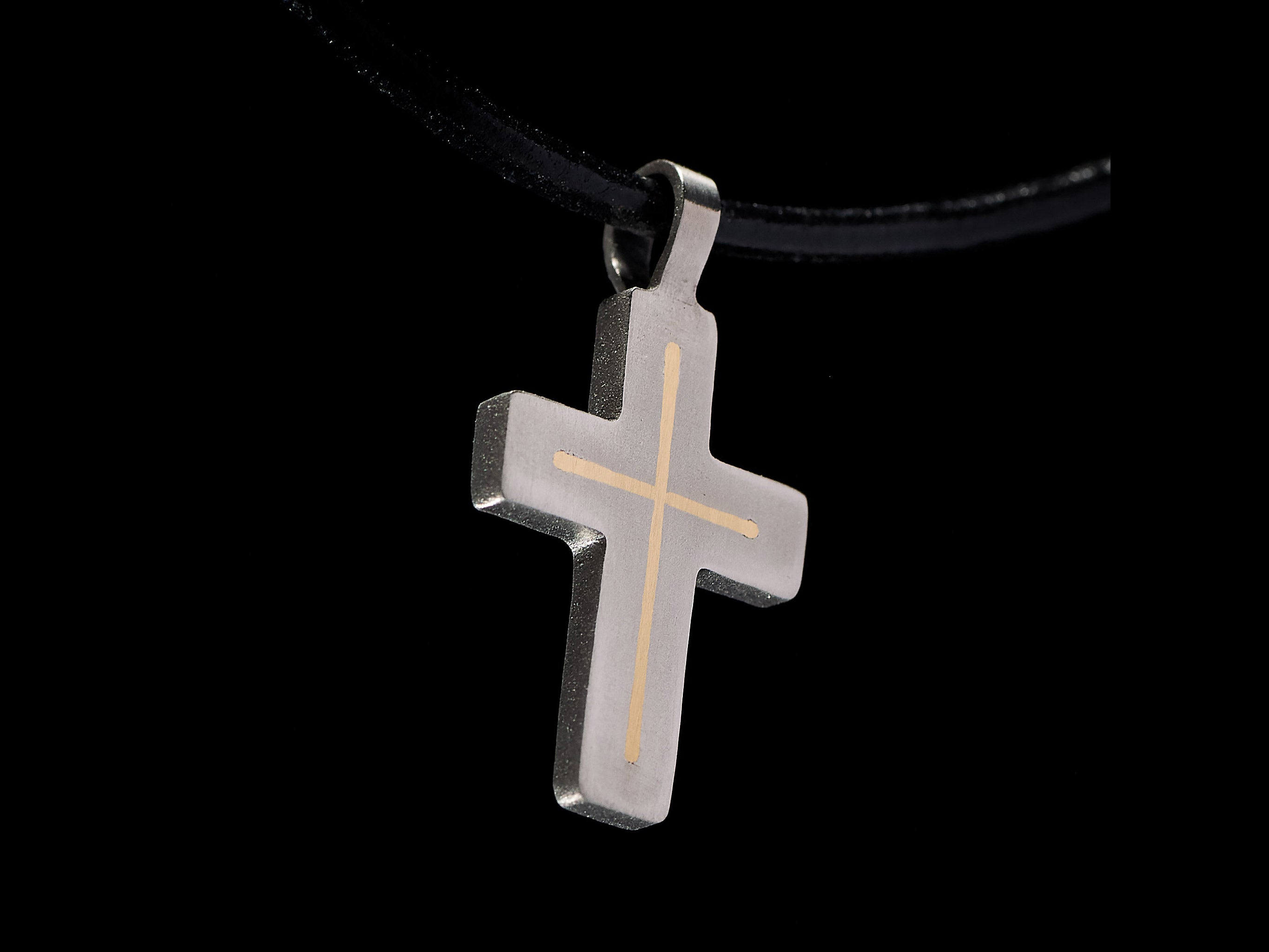 Handmade titanium cross pendant side view with brass inlay options