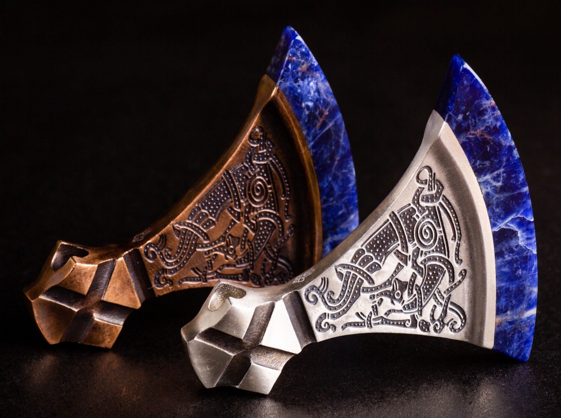 large silver and bronze viking axes with blue blades