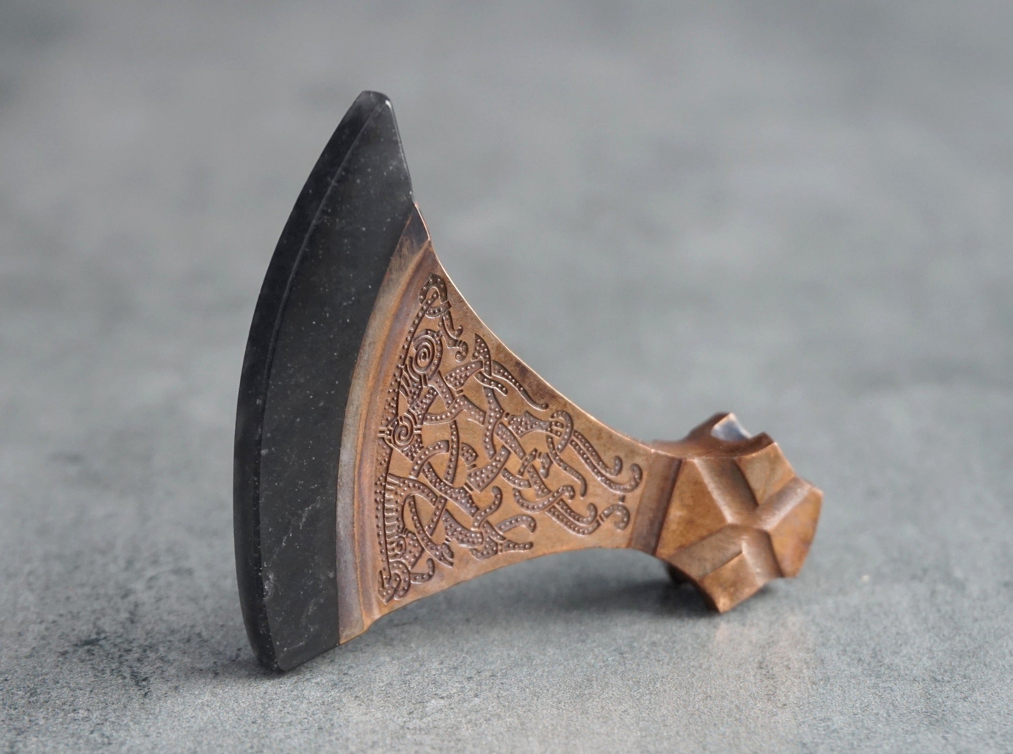 black obsidian blade of a bronze axe with white inclusions on the stone