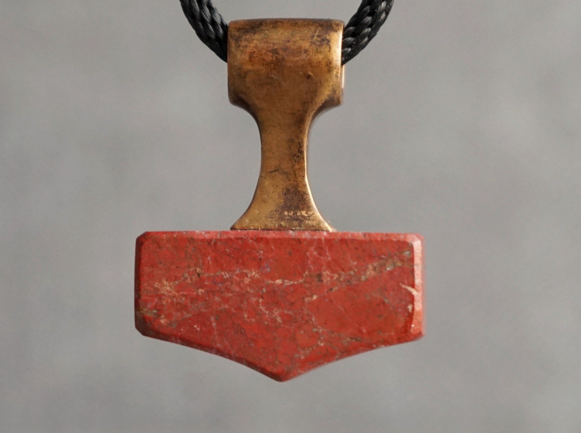small bronze and red stone mjolnir amulet