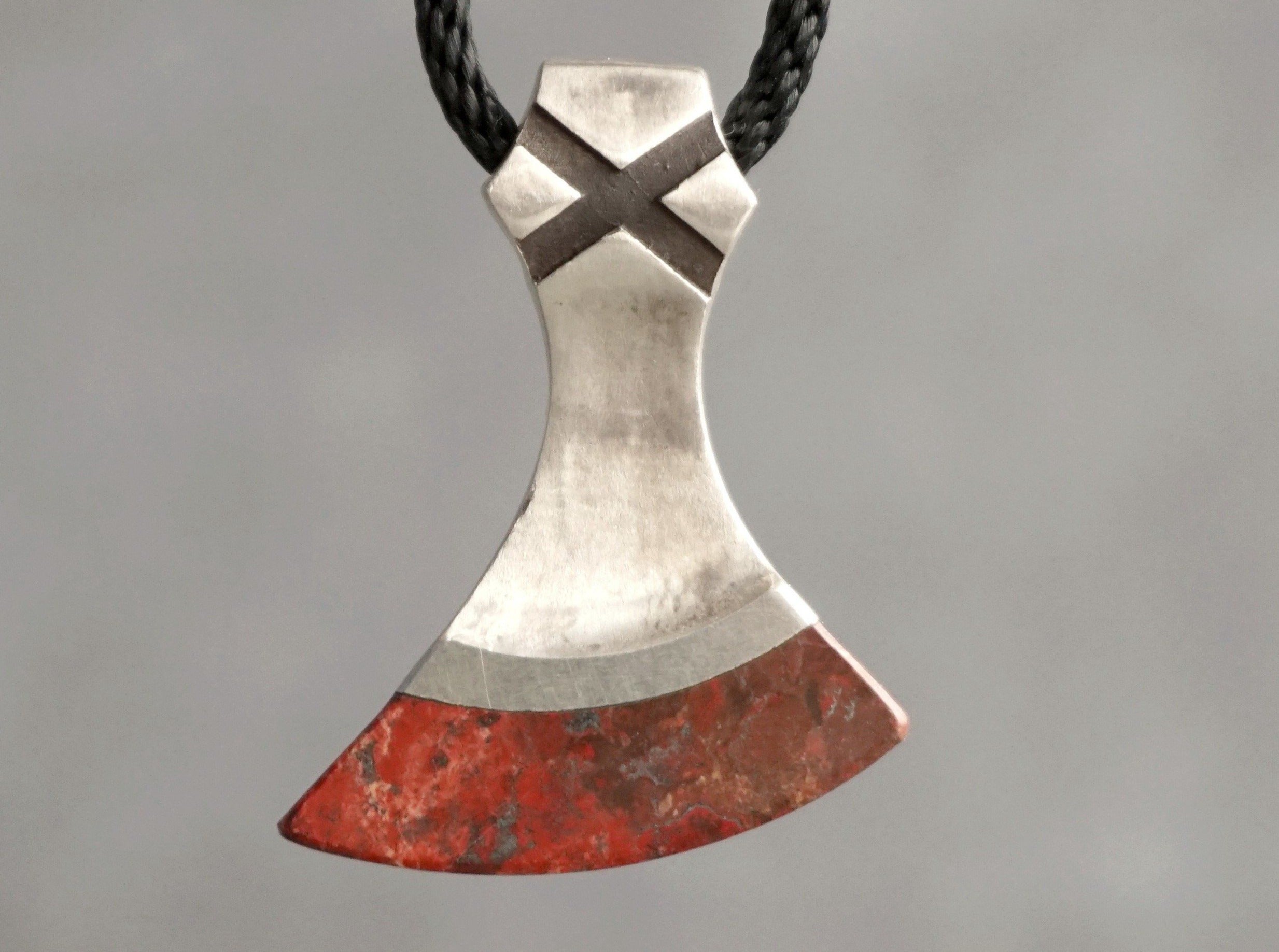 silver viking axe with red stone blade