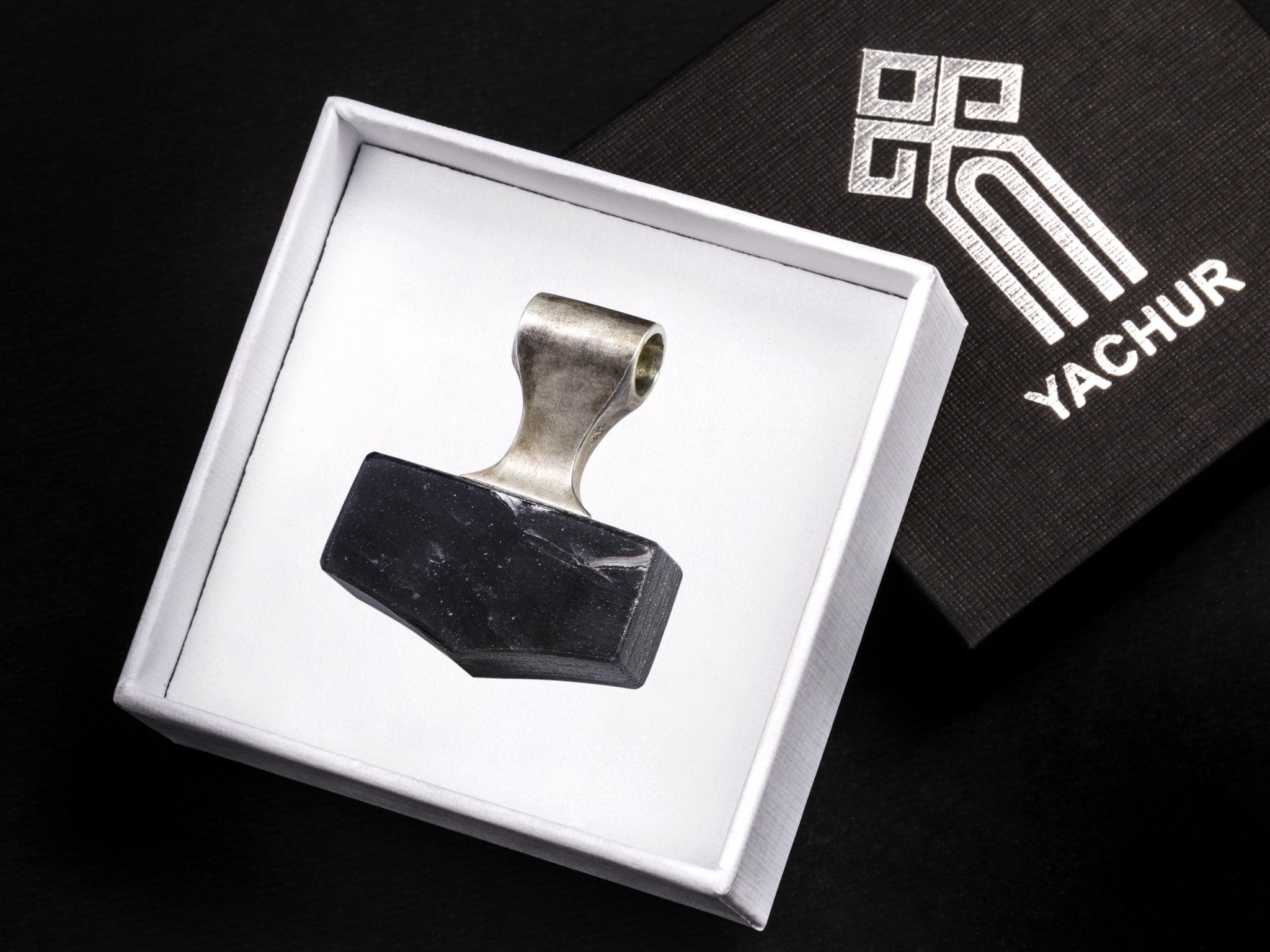 silver and black stone hammer pendant in a branded gift box
