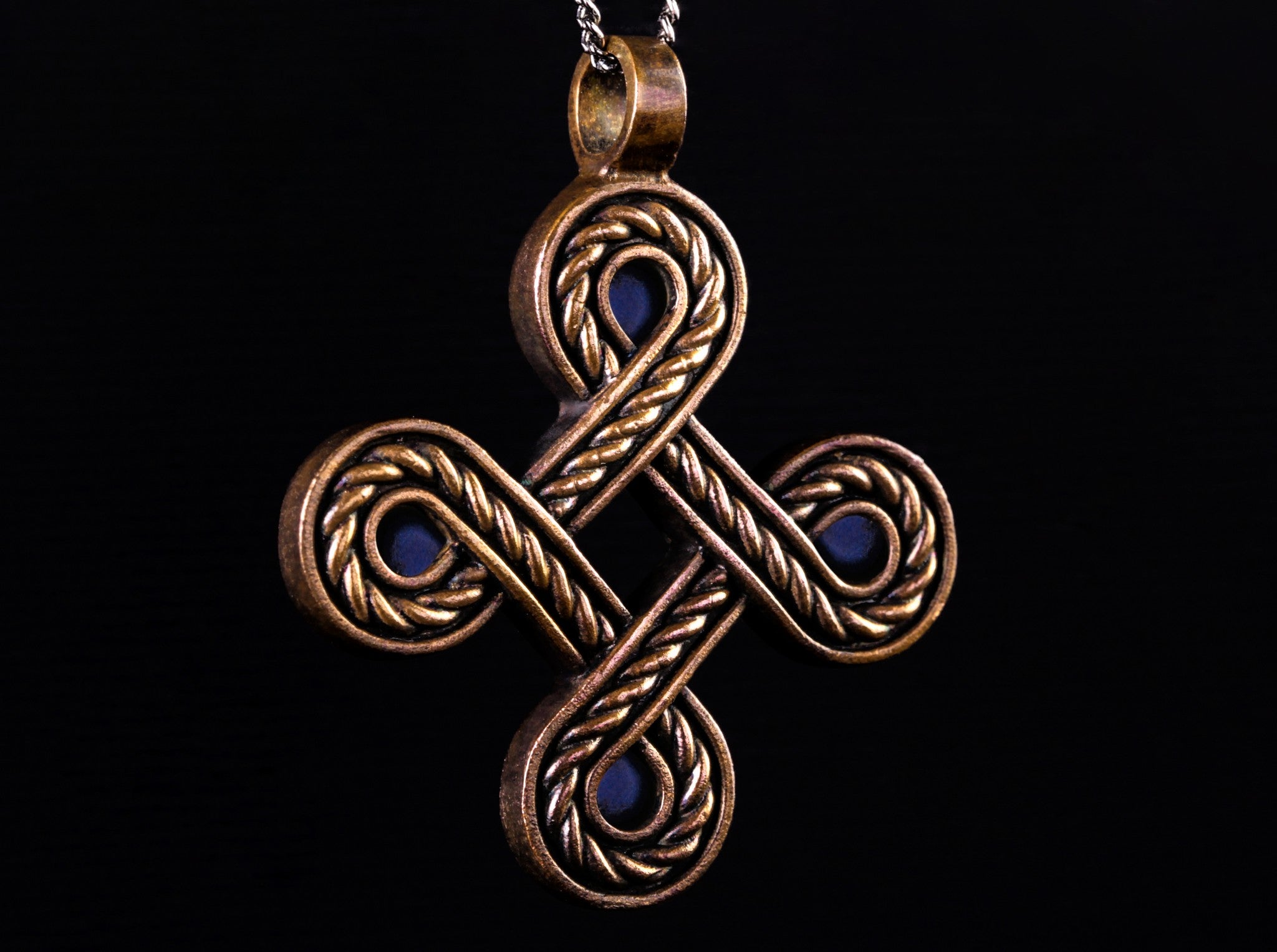 large rope-like bronze cross with blue stones