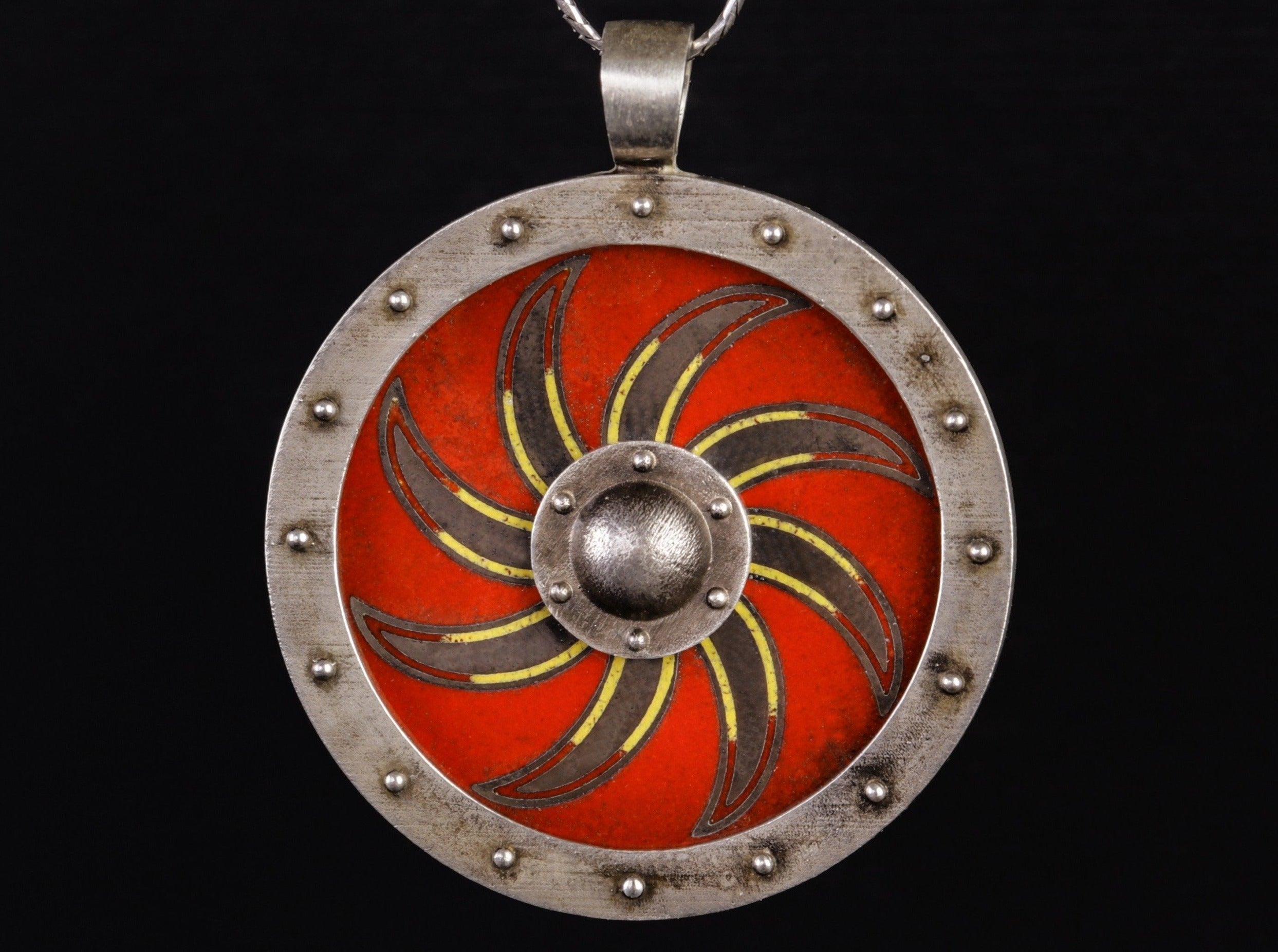 silver shield with solar symbol